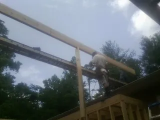 Carpenter setting a ridge beam over a new addition frame — Ice Dam Removal by Roofing Brothers in Mehoopany
