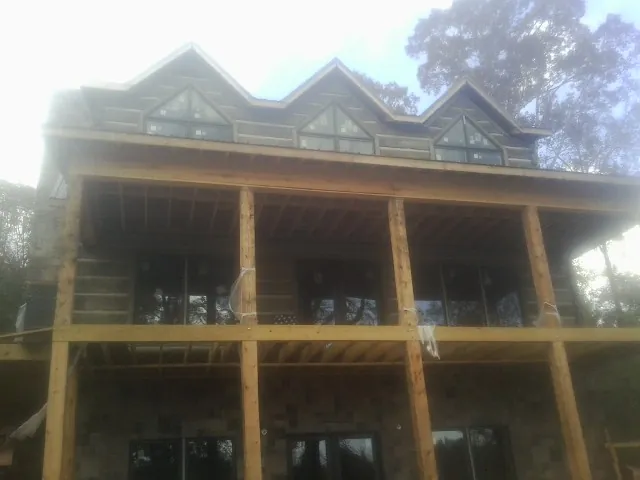 Dormers and porch framing on a large log home under construction — Roof Coating work by our crew in Mehoopany