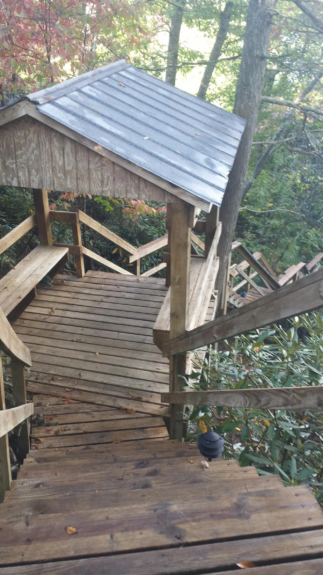 Metal roofed shelter over wooden steps on a wooded walkway — Skylight Repair & Installation work by our crew in Mehoopany