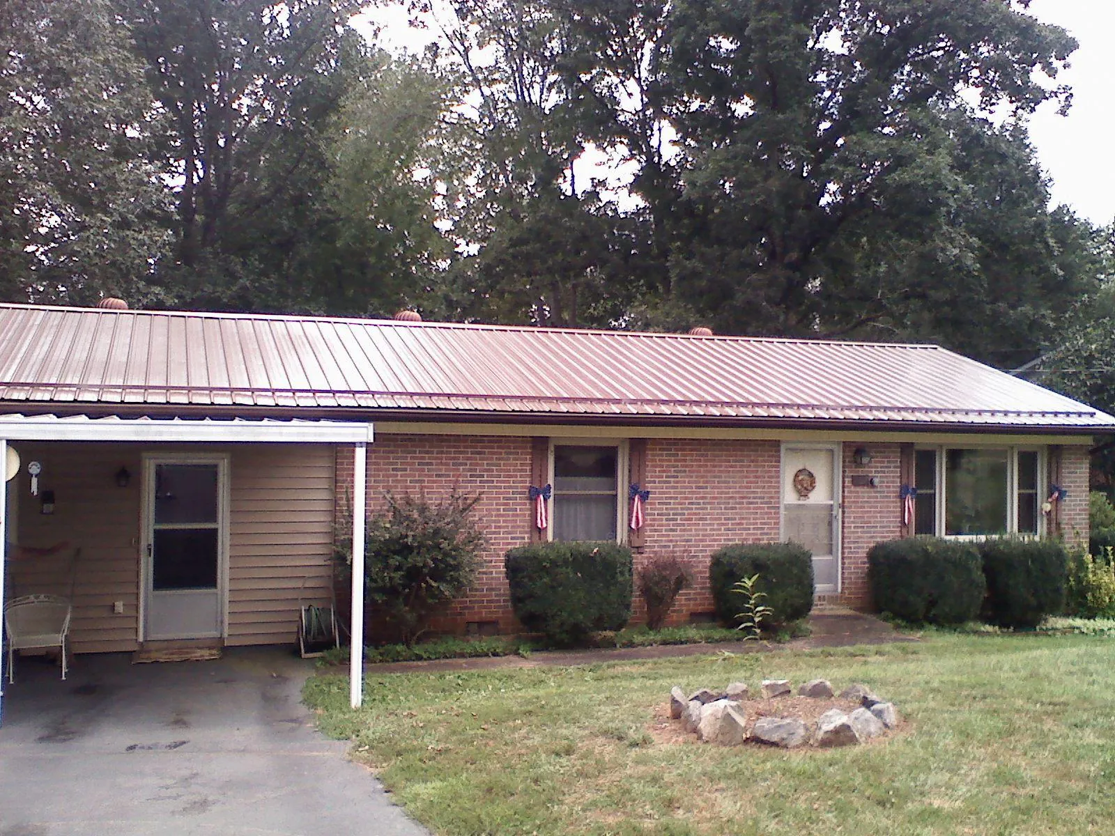 Bronze metal roof and carport on a brick ranch home — Roof Repair work by our crew in Mehoopany